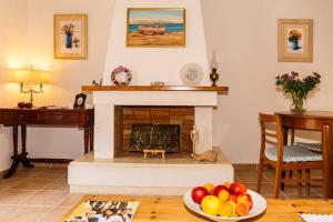 un soggiorno con camino e un piatto di frutta sul tavolo di Estia House Cozy-Comfortable Apartment a Benitses