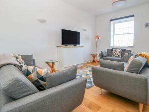 a living room with two couches and a flat screen tv at Swale View in Richmond