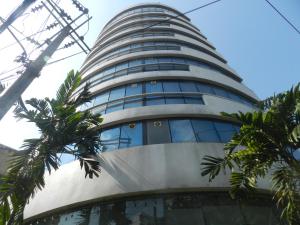 um edifício alto com palmeiras em frente em City Residence Rama 6 em Bangkok