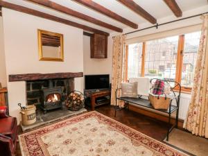 a living room with a fireplace and a couch at Middle Cottage in Stoke on Trent