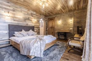 a bedroom with a bed and a desk and a chair at Маєток "ZYMON & SKI" in Bukovel
