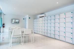 a dining room with white cabinets and a table and chairs at Bobopod Pancoran, Jakarta in Jakarta