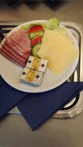 une assiette de fromage et d’autres denrées alimentaires sur une table dans l'établissement Blue River Side, à Blaustein