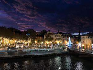 Una ciudad de noche con un árbol de Navidad y un puente en Hotel Ripa, en Bilbao