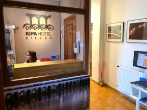 Kobieta siedząca za ladą restauracji w obiekcie Hotel Ripa w mieście Bilbao