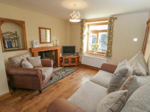 uma sala de estar com dois sofás e uma televisão em Eskside Cottage em Whitby