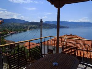 a table and chairs on a balcony with a view of a river at Grand View Kimon in Mithymna