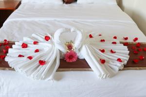 een bed met twee witte handdoeken en harten erop bij Khách sạn Trường Long in Phan Rang +1 foto