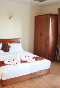 een slaapkamer met twee bedden met rozen erop bij Khách sạn Trường Long in Phan Rang