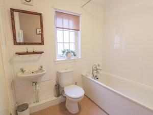een badkamer met een toilet, een wastafel en een spiegel bij Turret Cottage in Prestonpans +9 foto's