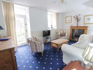 uma sala de estar com um sofá e cadeiras e uma lareira em Turret Cottage em Prestonpans