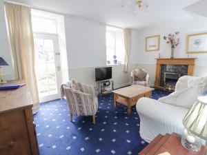 a living room with a couch and chairs and a fireplace at Turret Cottage in Prestonpans