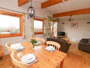 comedor y sala de estar con mesa de madera y sillas en Barn Owl Lodge, en Rhayader