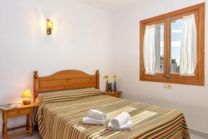 1 dormitorio con 1 cama con 2 toallas en Lladoner 2G, en Puerto Pollensa