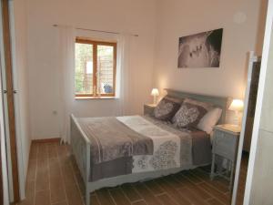 una camera da letto con un letto e una finestra di Les Tachats a Hautefort Altre 11 foto