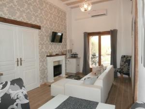 un soggiorno con un divano bianco e un camino di Les Tachats a Hautefort