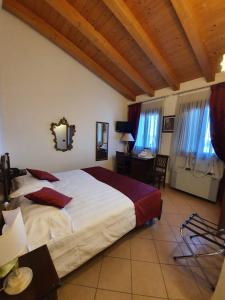 a bedroom with a large bed and a desk and windows at Agriturismo Eva in Favaro Veneto