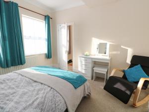 1 dormitorio con cama, silla y escritorio en The Waiting Room, en Norwich