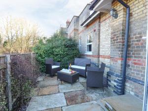 a patio with chairs and a table on a brick wall at The Waiting Room in Norwich