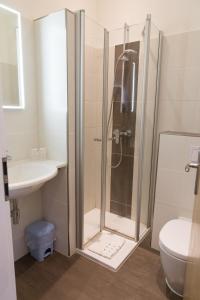 a bathroom with a shower and a toilet and a sink at Hotel Restaurant Lathener Marsch in Lathen