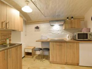 a kitchen with a counter with two stools and a microwave at Aura in Lewin Kłodzki