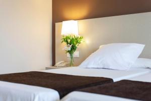 a bedroom with a bed with a lamp and a phone at Helios Benidorm in Benidorm