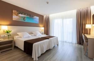 a hotel room with a bed and a large window at Helios Benidorm in Benidorm