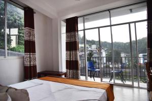Un dormitorio con una cama y una ventana grande. en Lodge in 611, en Kandy