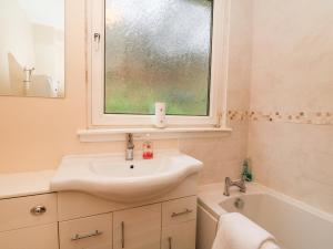 a bathroom with a sink and a window and a tub at Glenfinglas Dam Cottage in Callander +17 photos