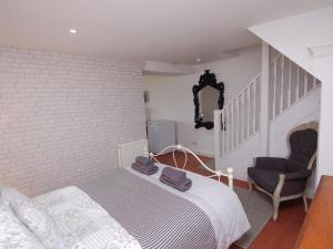 um quarto com uma cama e uma cadeira em Hidden Treasure em Brixham