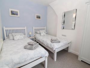 two twin beds in a room with a mirror at Park View Cottage in Mold