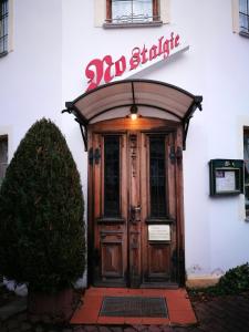 eine Holztür eines Gebäudes mit einem Schild darüber in der Unterkunft Pension & Gasthaus Nostalgie in Chemnitz