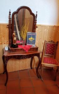 a table with a mirror next to a chair at Pension & Gasthaus Nostalgie in Chemnitz