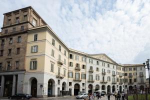 Dynasty Suites Downtown Apartments في تورينو: مبنى كبير على شارع فيه سيارات تقف امامه