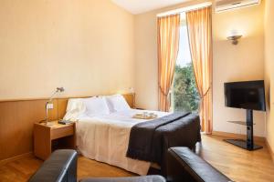 Habitación de hotel con cama y TV en Dynasty Suites Downtown Apartments en Turín