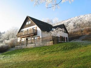 a large house with a black roof on a hill at In der Waldemei in Medebach