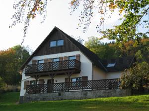 a white house with a black roof and a balcony at In der Waldemei in Medebach