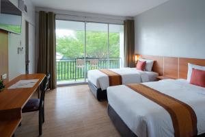 a hotel room with two beds and a balcony at Royal Lanta Resort & Spa in Ko Lanta