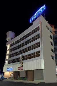 a building with a sign on top of it at Central Beacon Hotel in Surat
