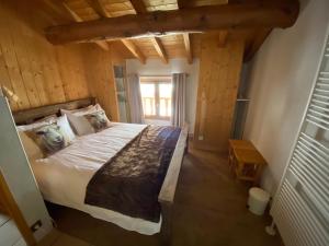 ein Schlafzimmer mit einem großen Bett und einem Fenster in der Unterkunft Monster Chalets in Le Bettaix