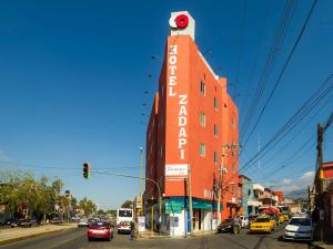 a red building with a sign on it on a city street at Hotel Zadapi in Oaxaca City