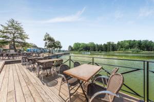 une terrasse avec des tables et des chaises à côté d'une rivière dans l'établissement Village Pierre & Vacances Belle Dune, à Fort-Mahon-Plage