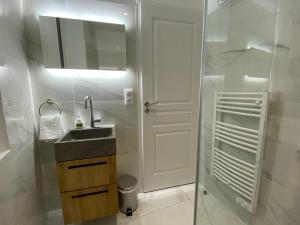 a white bathroom with a sink and a mirror at Le Standing - Au Coeur d'Agen - Self Checkin - Wifi - Netflix - Smart TV - Luqs fr in Agen