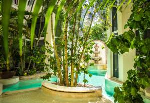 a swimming pool with palm trees in a building at Royal Palms 10 condo in Playa del Carmen