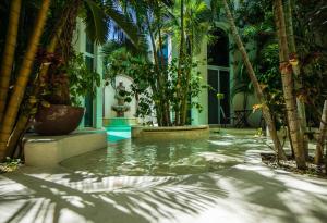 a courtyard with palm trees and a pool of water at Royal Palms 10 condo in Playa del Carmen