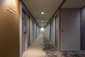 an empty corridor with a row of doors and a long hallway at Shinjuku Washington Hotel Annex in Tokyo