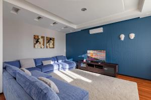 a blue living room with a couch and a tv at Zhilyanskaya 30а apartments in Kyiv