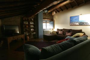 a living room with a couch and a tv at La Casa de los Arribes in Fornillos de Fermoselle