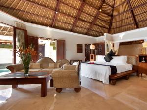 a bedroom with a bed and a living room at Viceroy Bali in Ubud