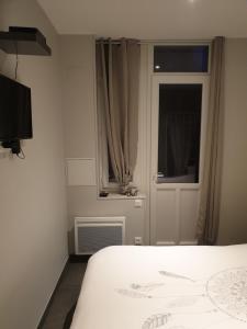 クリエル・シュル・メールにあるLe clos du val de merのベッドルーム1室(ベッド1台付)、窓、ドアが備わります。